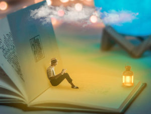Homem lendo dentro de um livro gigante para expressar a ideia de gostar de ler ou ter prazer na leitura. 